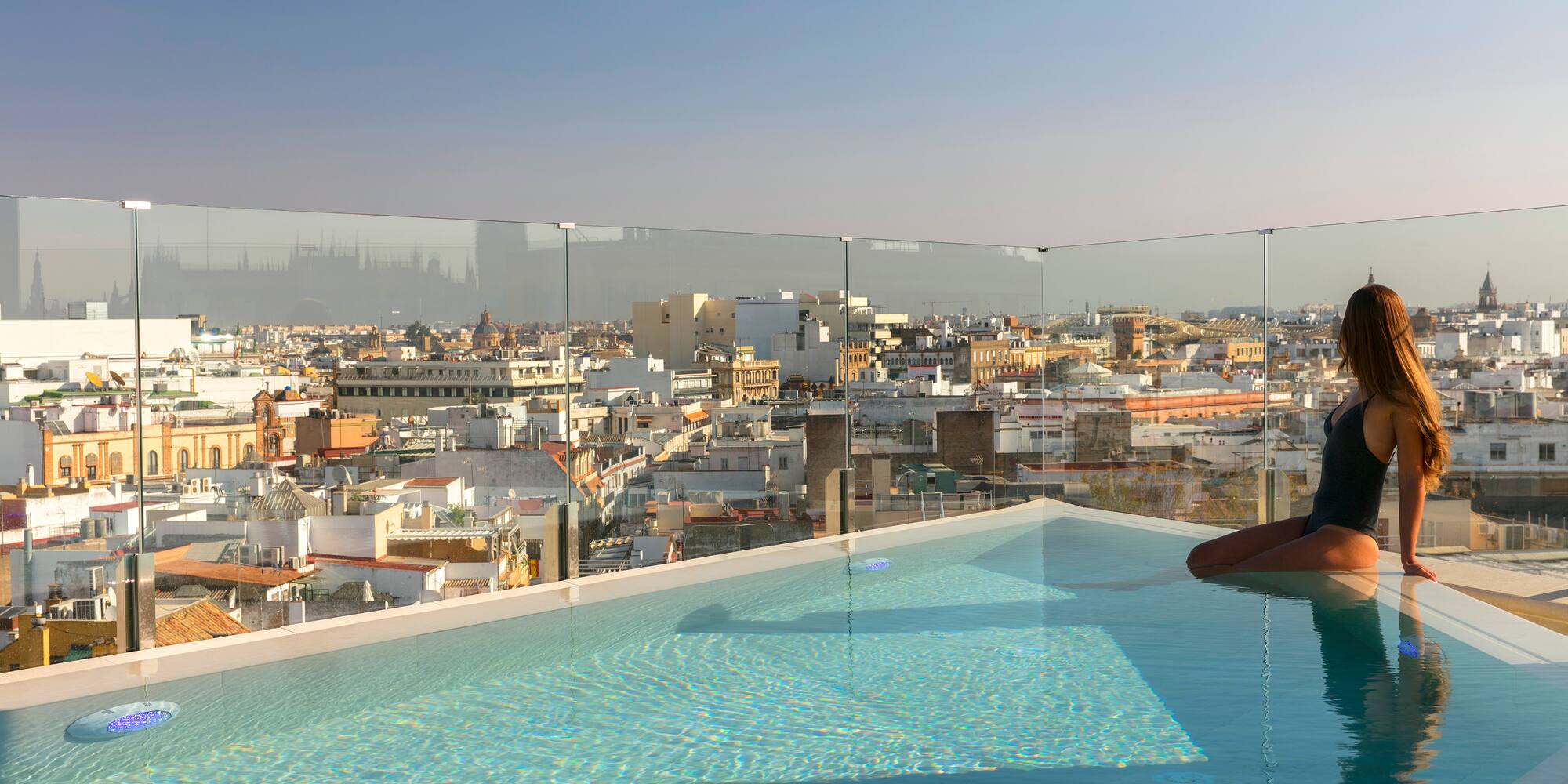 a person in a pool with a city in the background