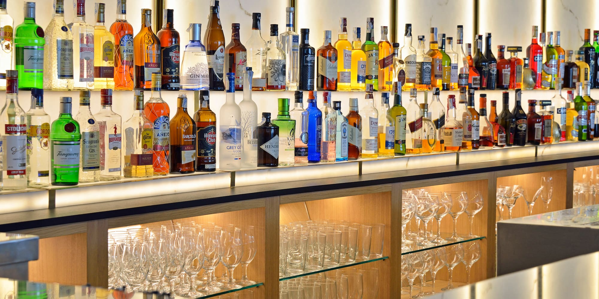 a shelf of liquor bottles and glasses