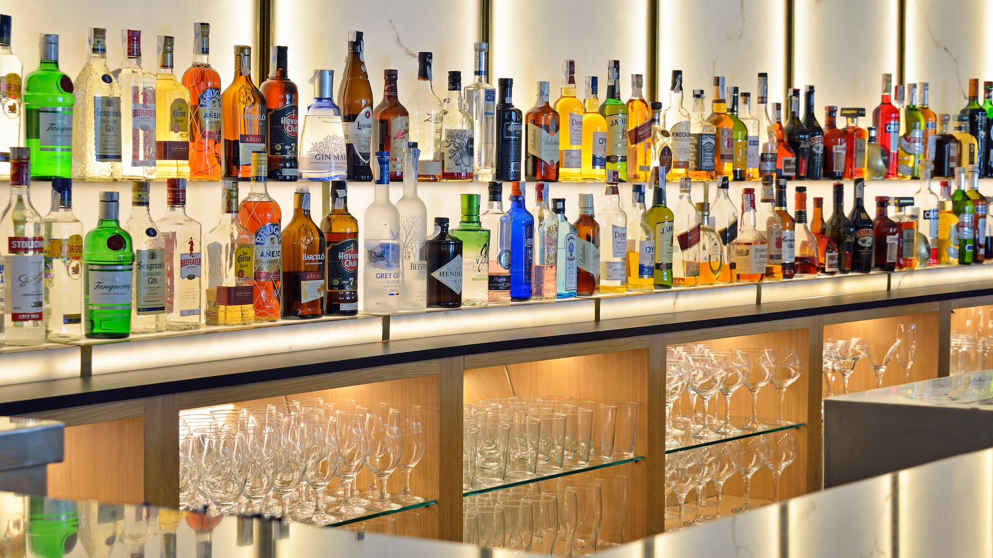 a shelf of liquor bottles and glasses