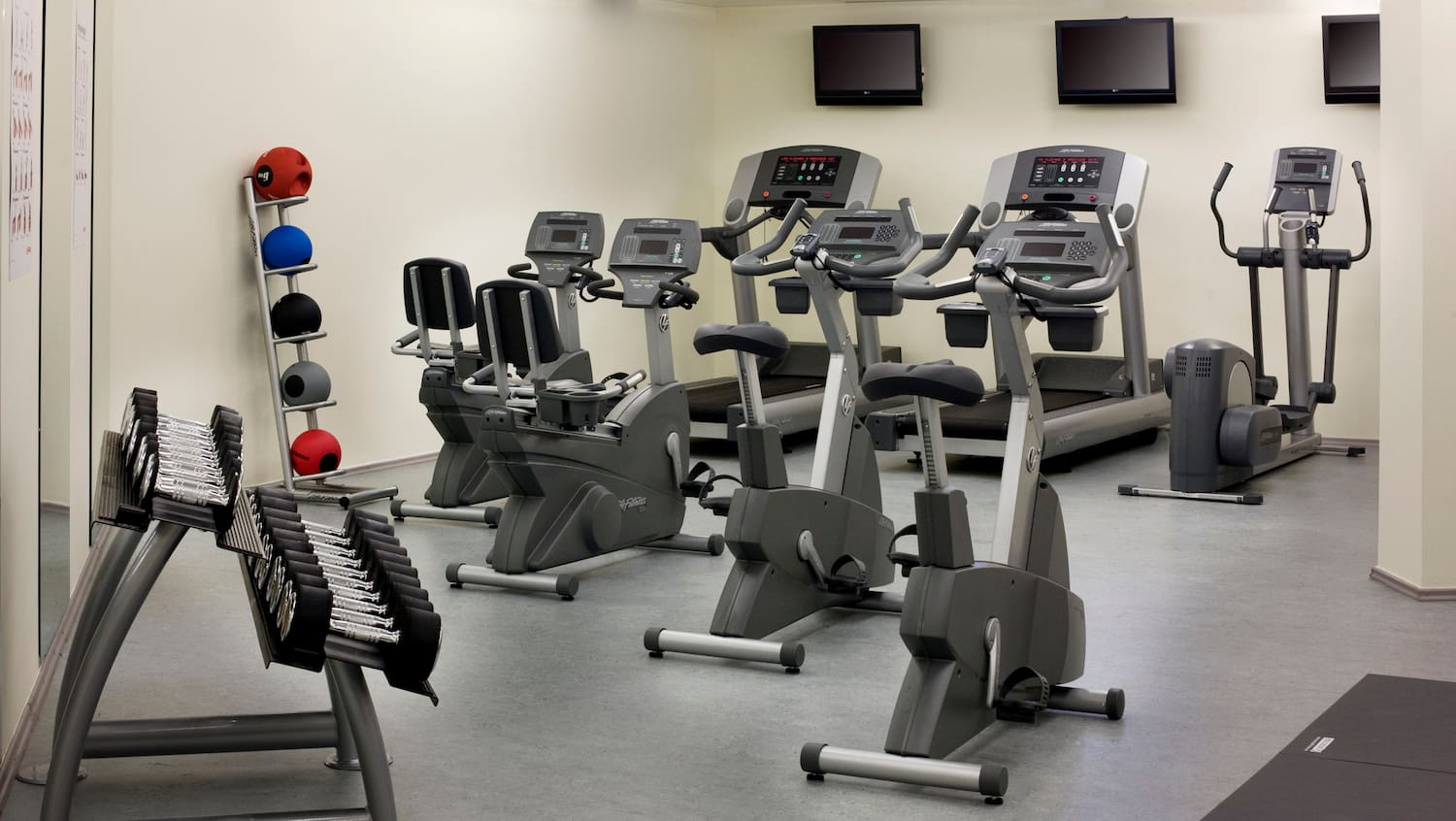 a room with exercise bikes and monitors
