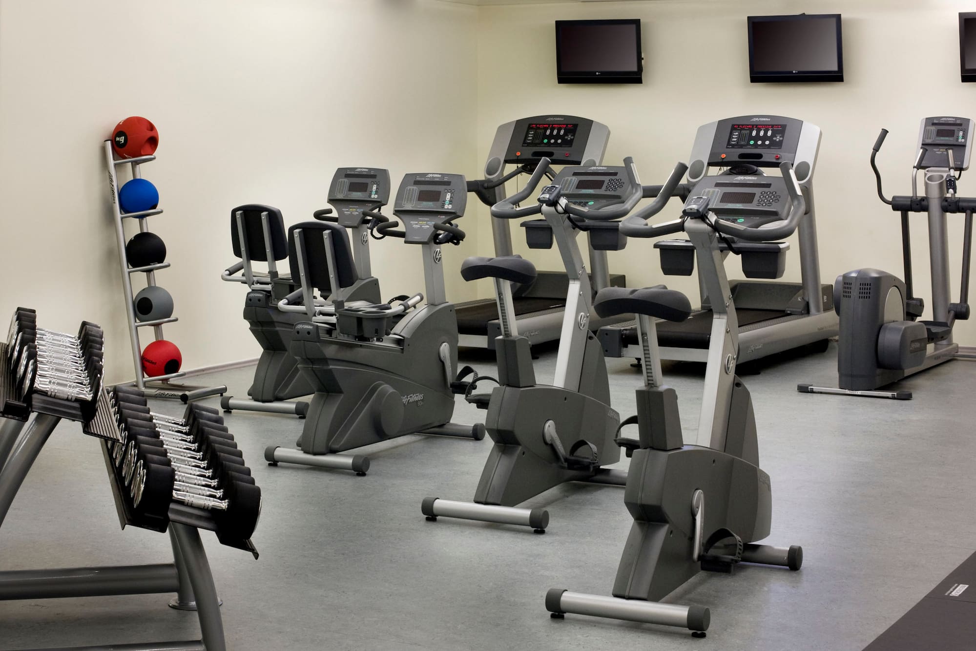 a room with exercise bikes and monitors