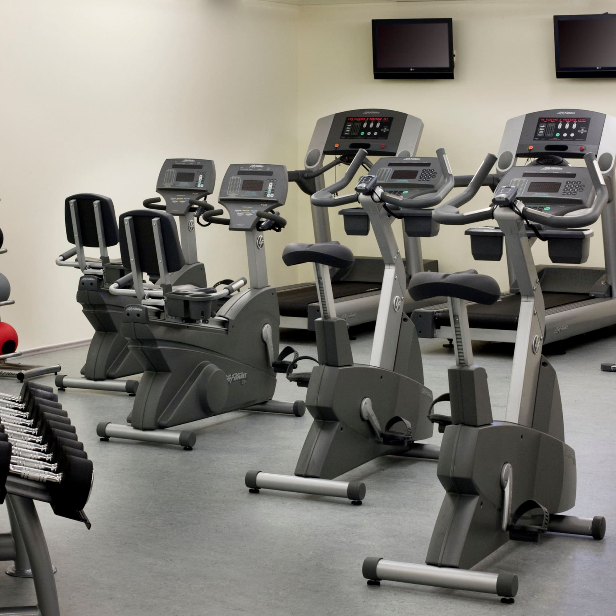 a room with exercise bikes and monitors