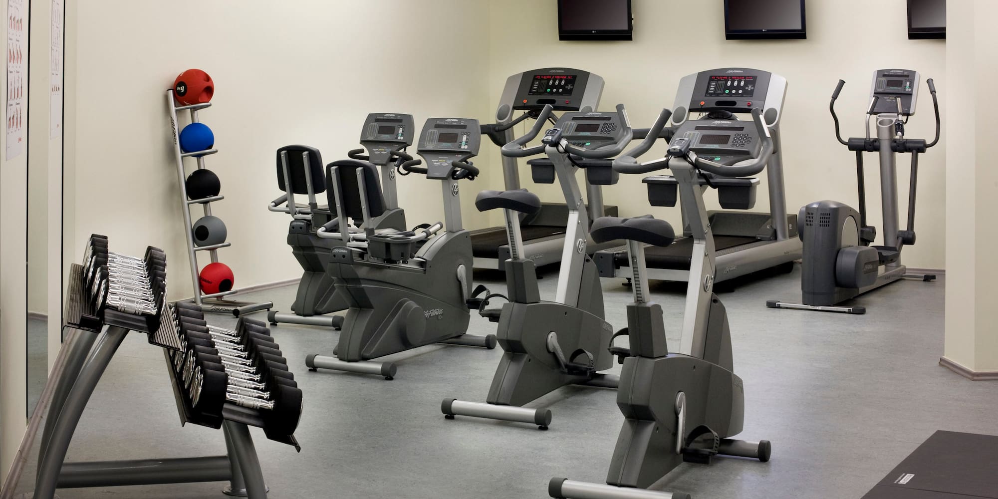 a room with exercise bikes and monitors