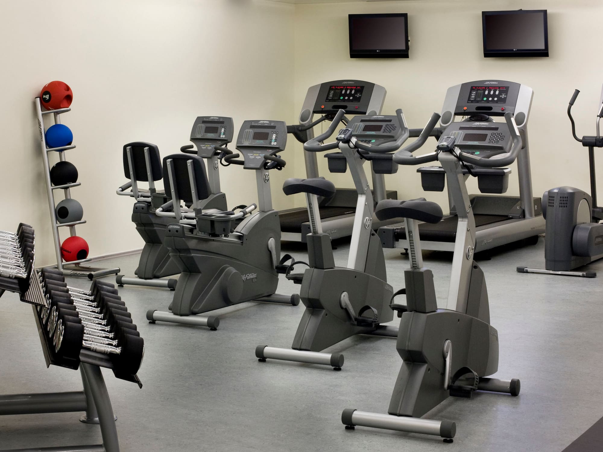 a room with exercise bikes and monitors