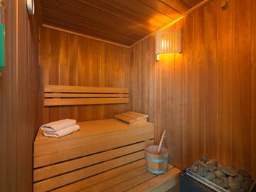 a wooden sauna with a bucket and a towel