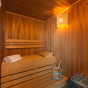 a wooden sauna with a bucket and a towel