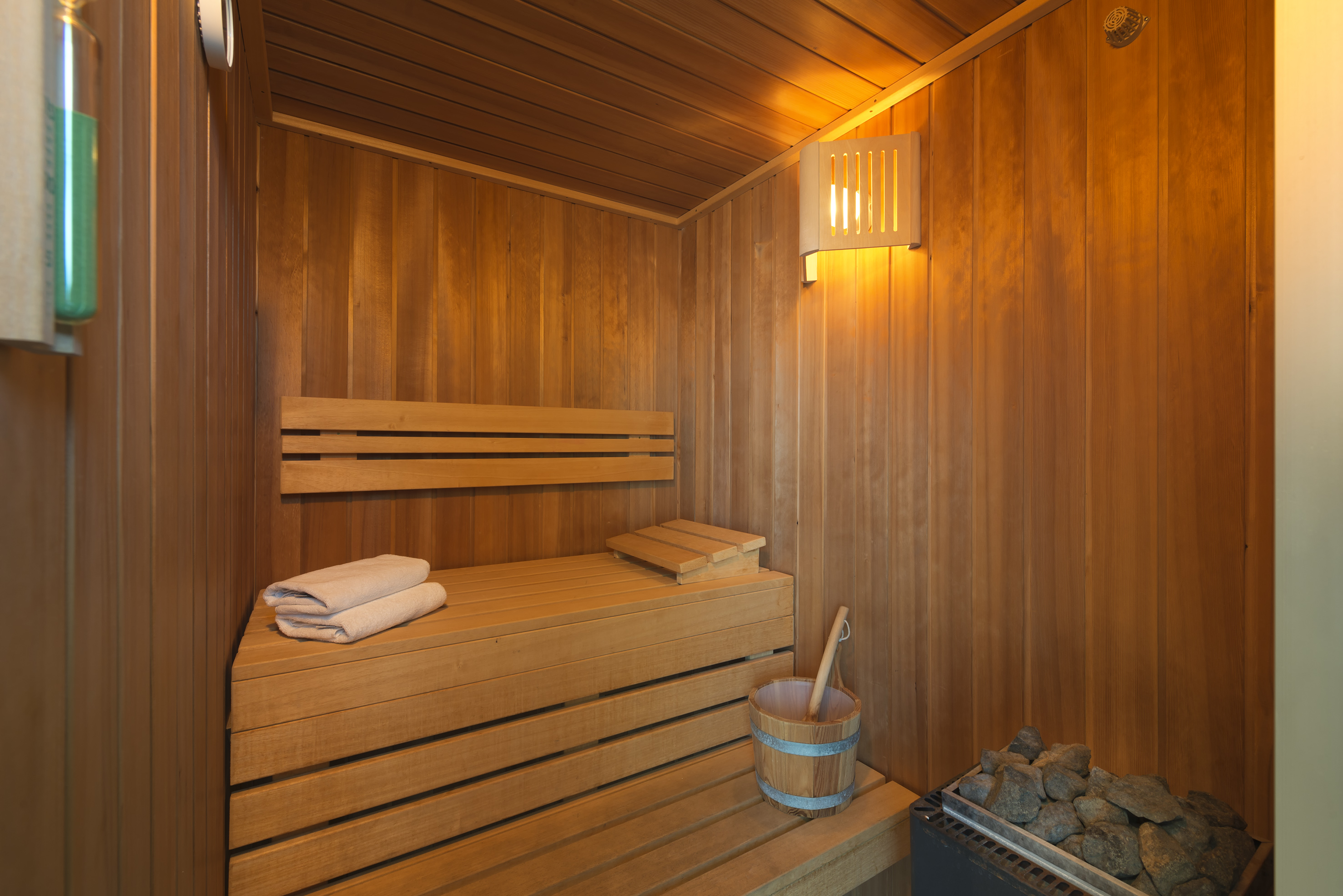 a wooden sauna with a bucket and a towel