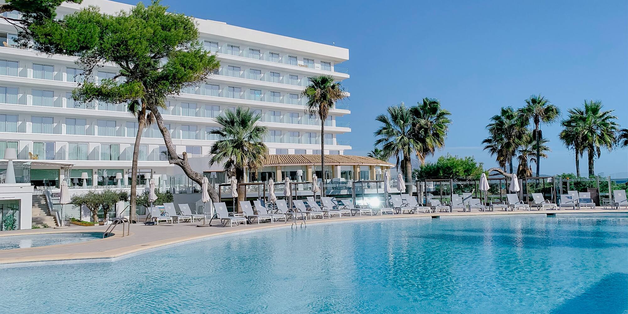 a pool with palm trees and a building in the background