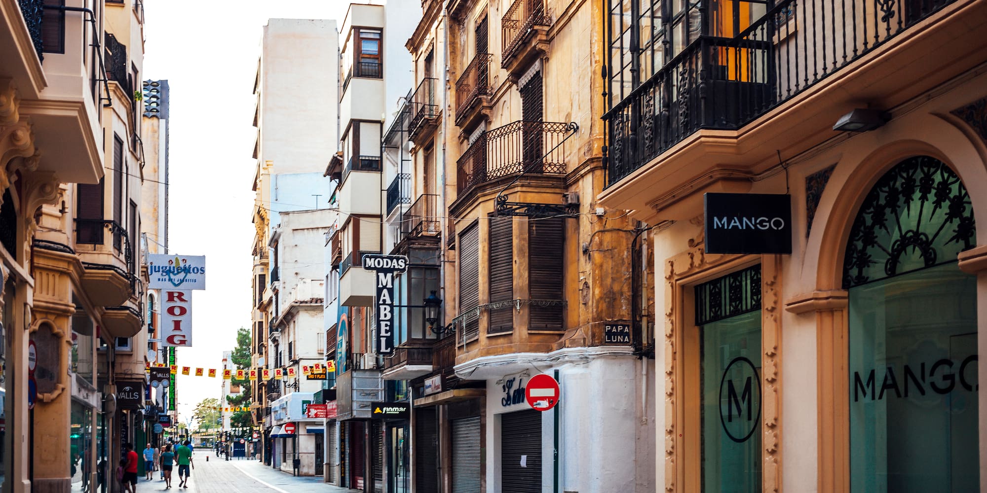 a street with buildings and people walking on it