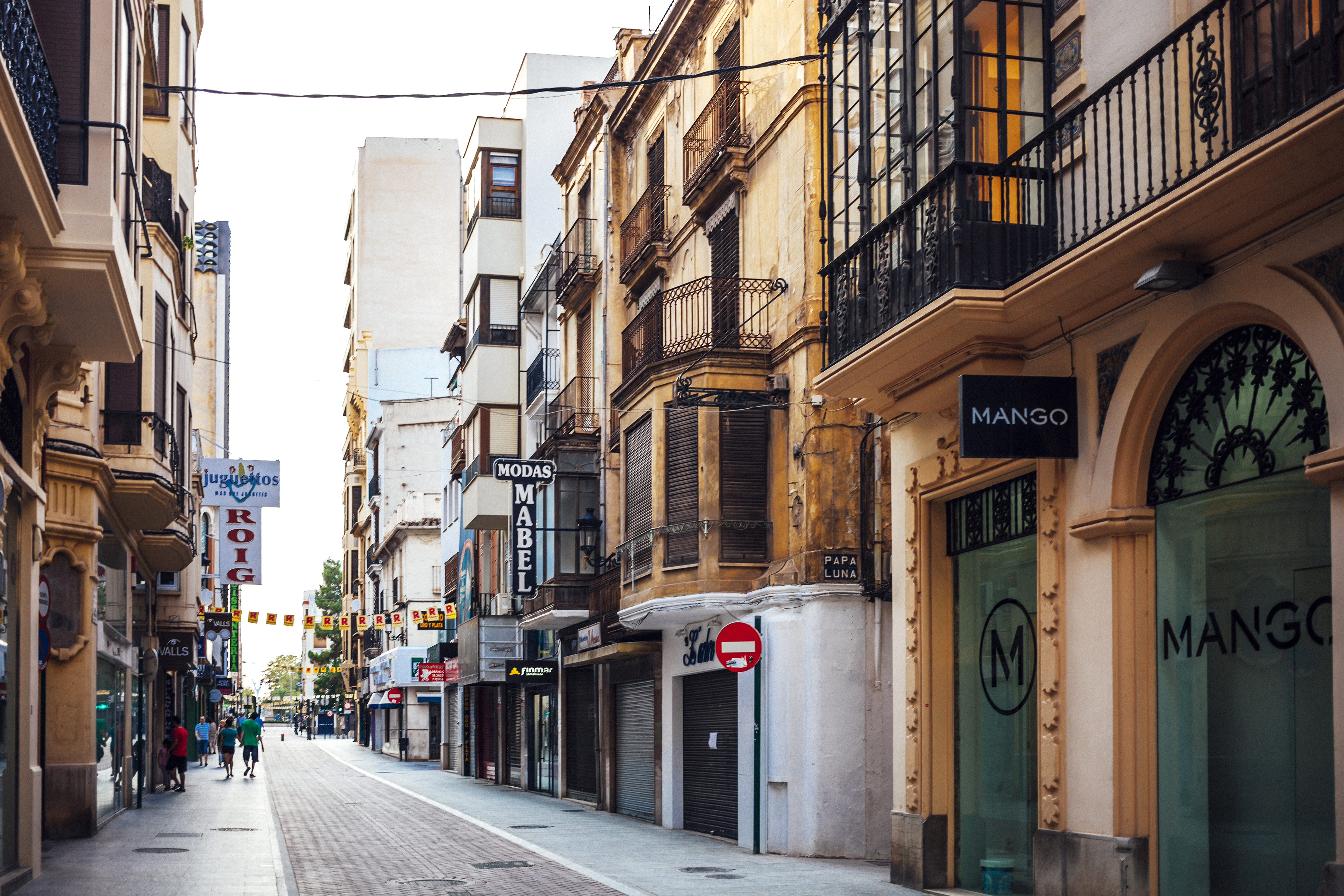 a street with buildings and people walking on it