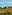 Bellver Castle, Mallorca, on a forested hill under blue sky.