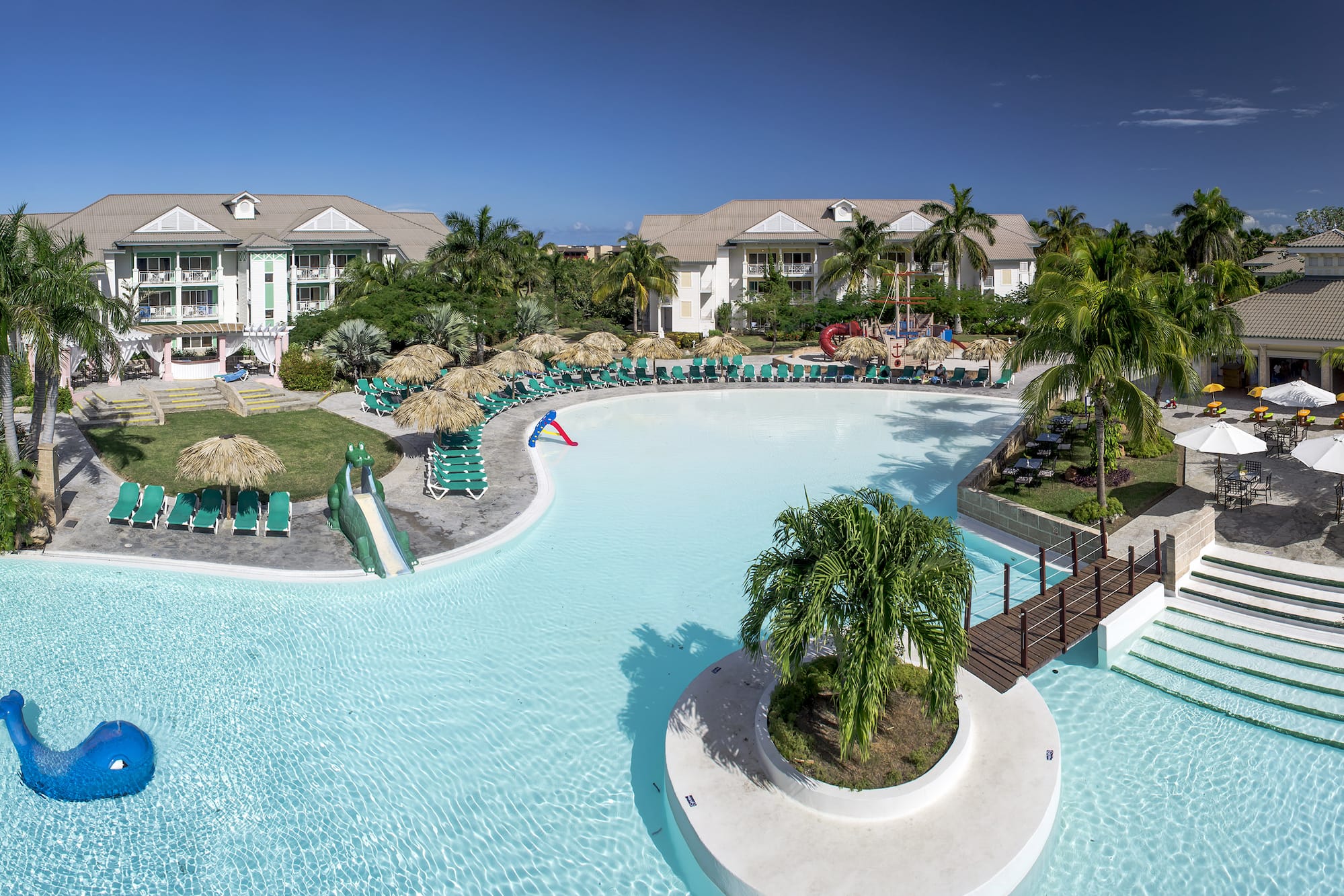 a swimming pool with a slide and palm trees
