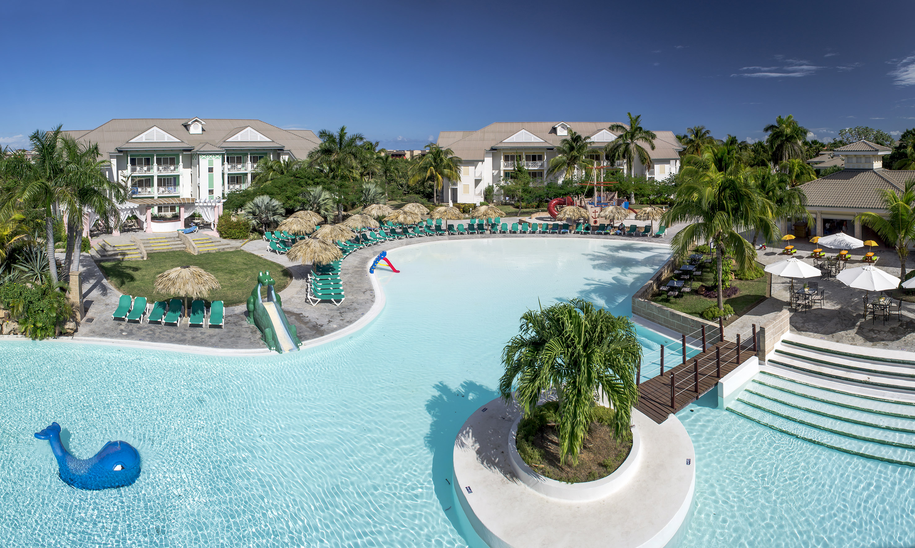 a swimming pool with a slide and palm trees