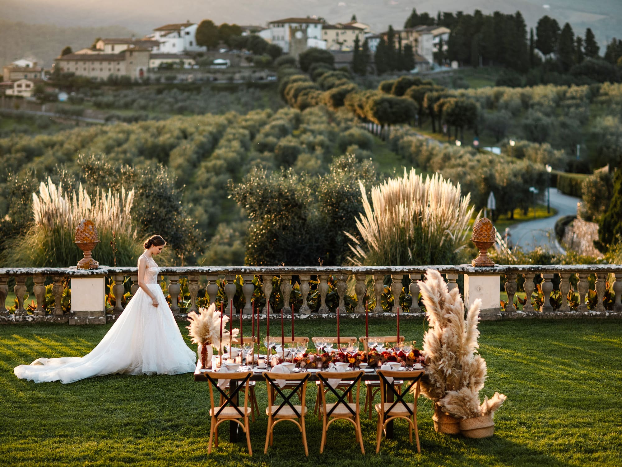 a woman in a white dress standing in front of a table with food