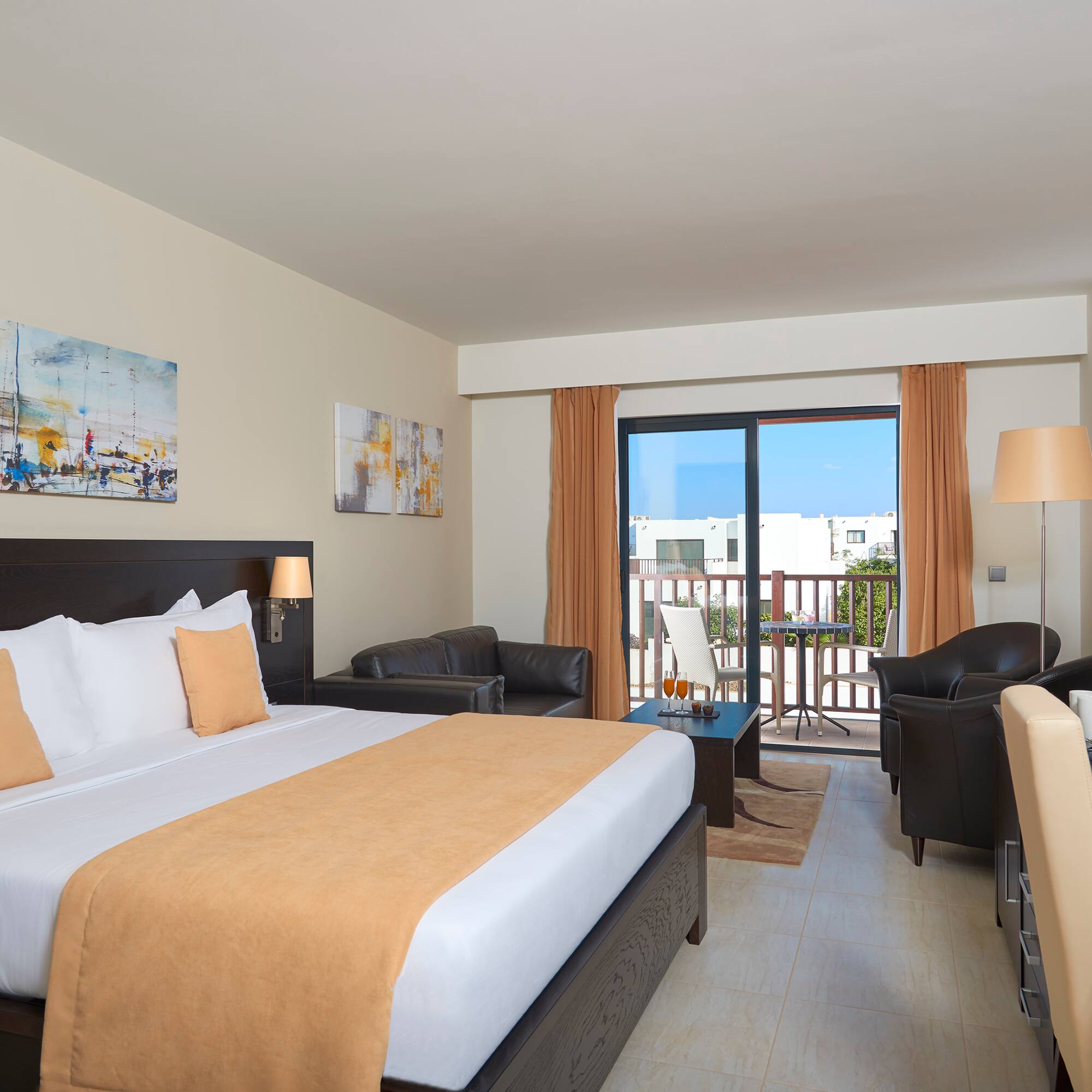 a room with a bed and chairs