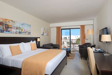 a room with a bed and chairs