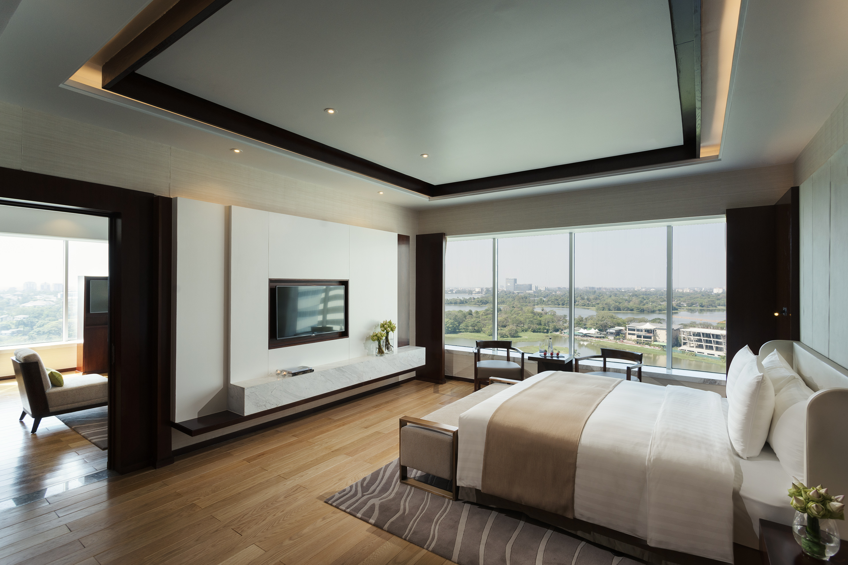 Luxury hotel bedroom with lake view, king bed, and modern decor.