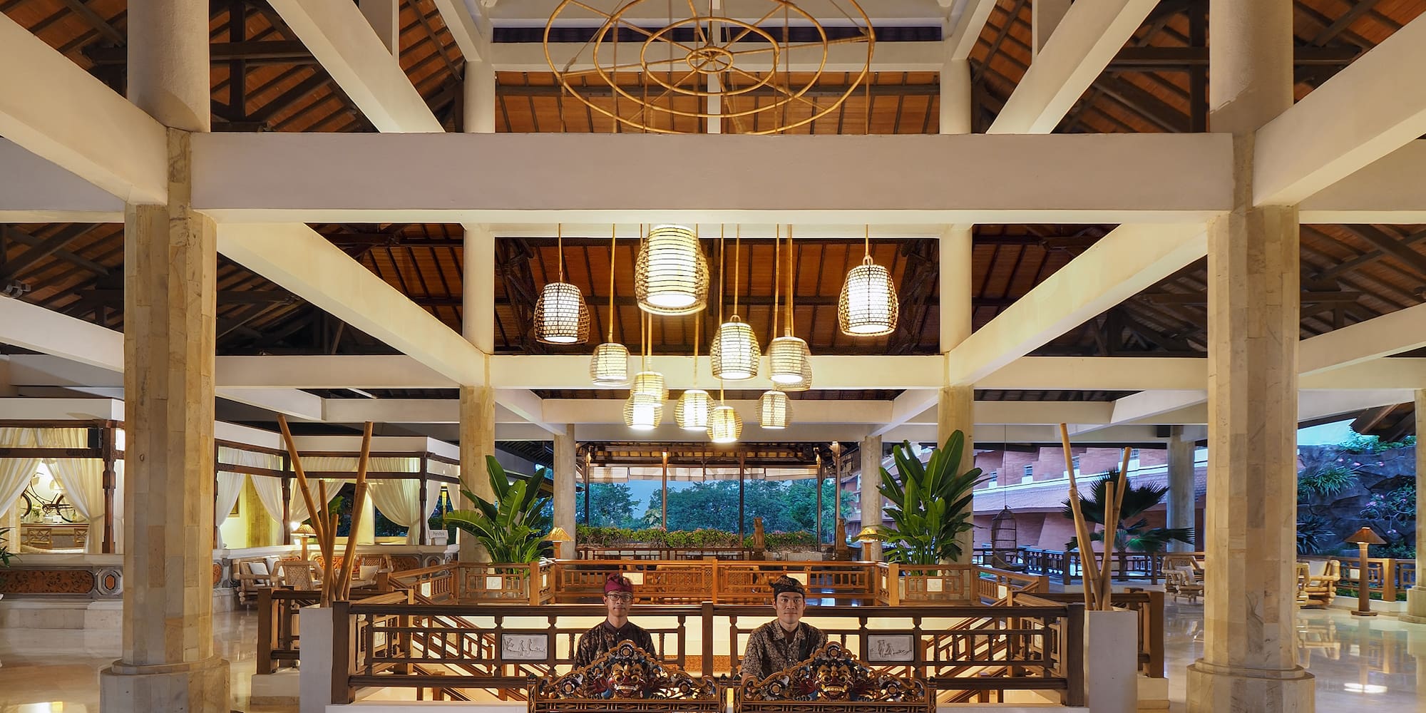 a couple of people sitting in a room with a large ceiling