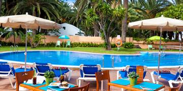 a pool with tables and chairs and umbrellas