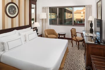 a room with a bed and chairs