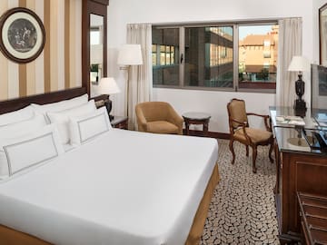 a room with a bed and chairs