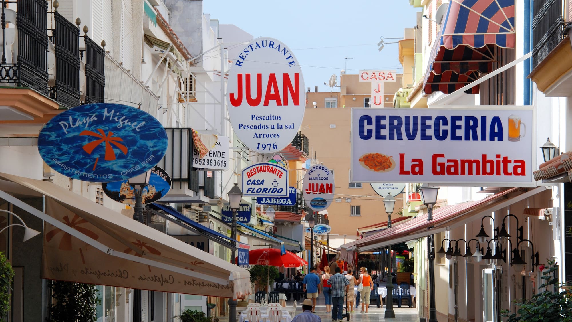 a street with signs and people walking