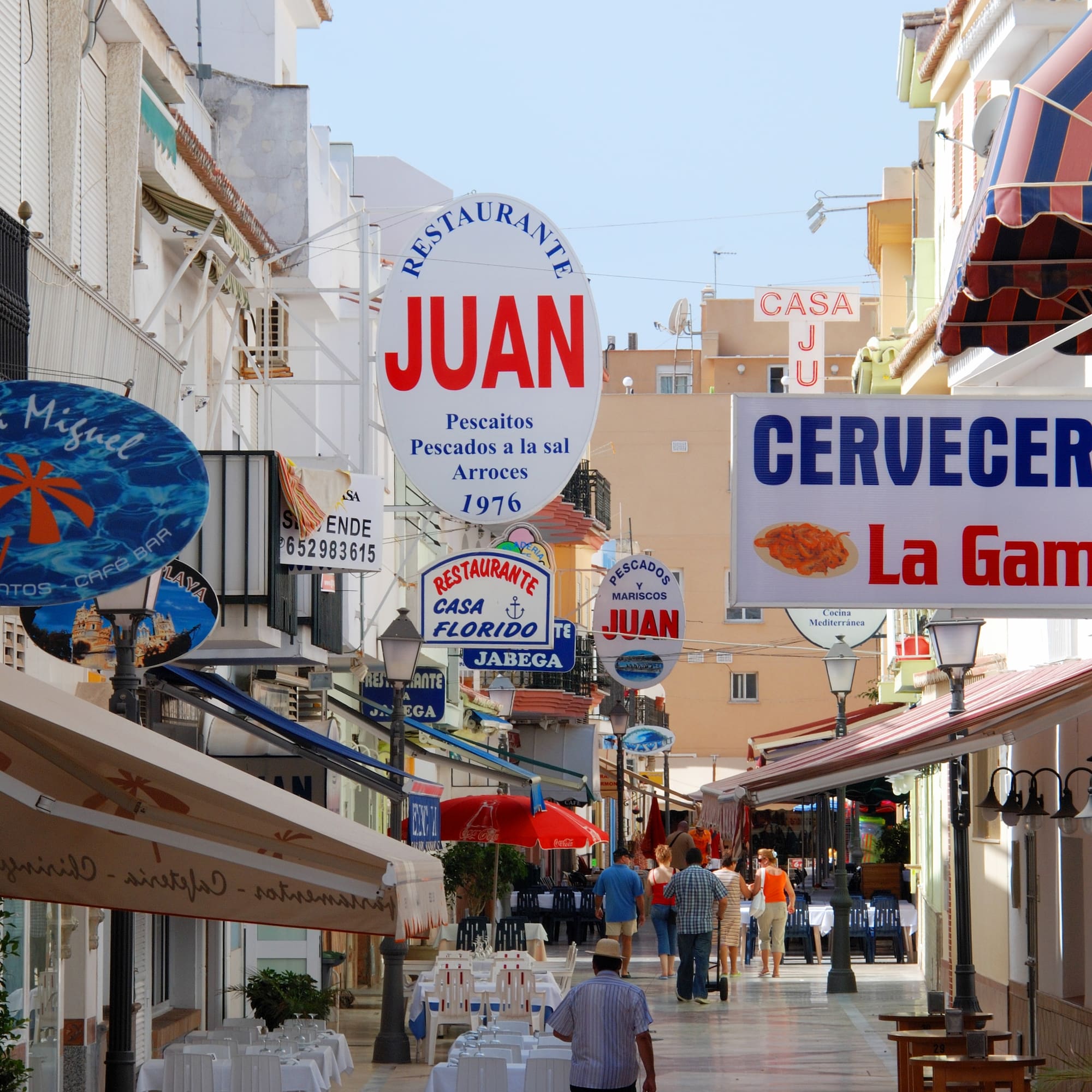 a street with signs and people walking