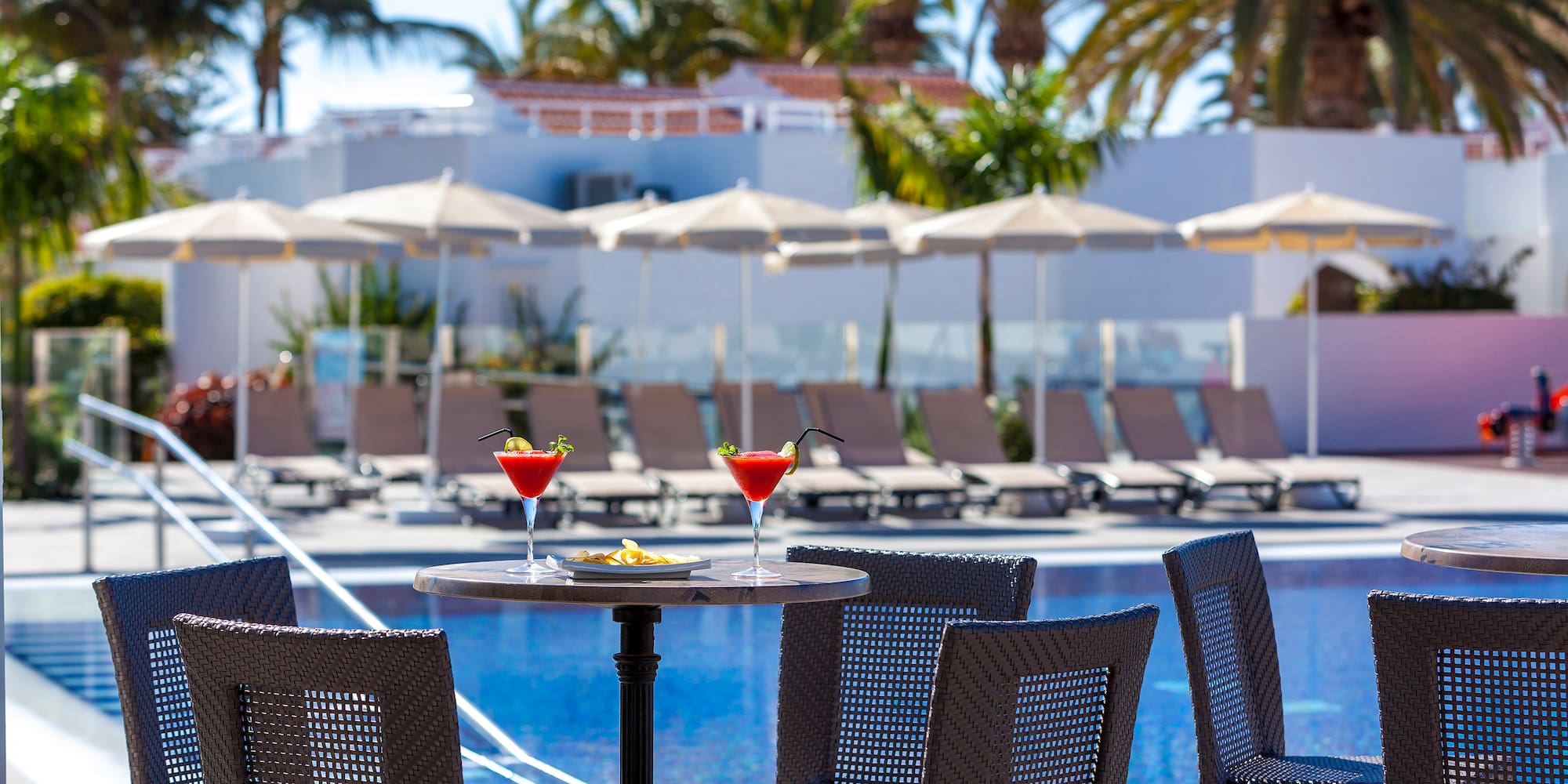 a table with drinks on it by a pool