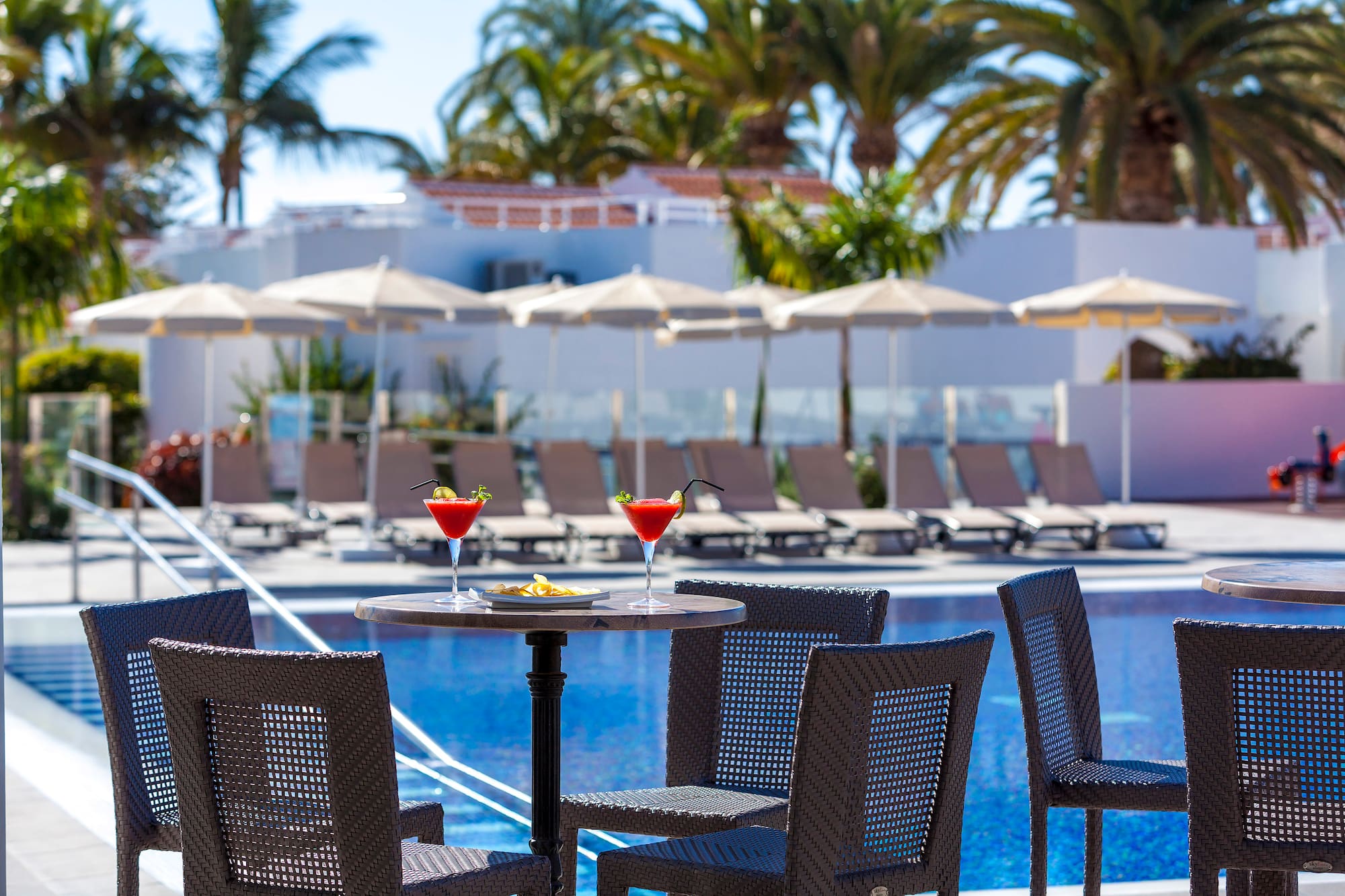 a table with drinks on it by a pool
