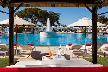 a pool with a fountain and a table with drinks