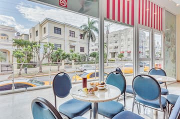 a table with food on it and blue chairs in front of a window