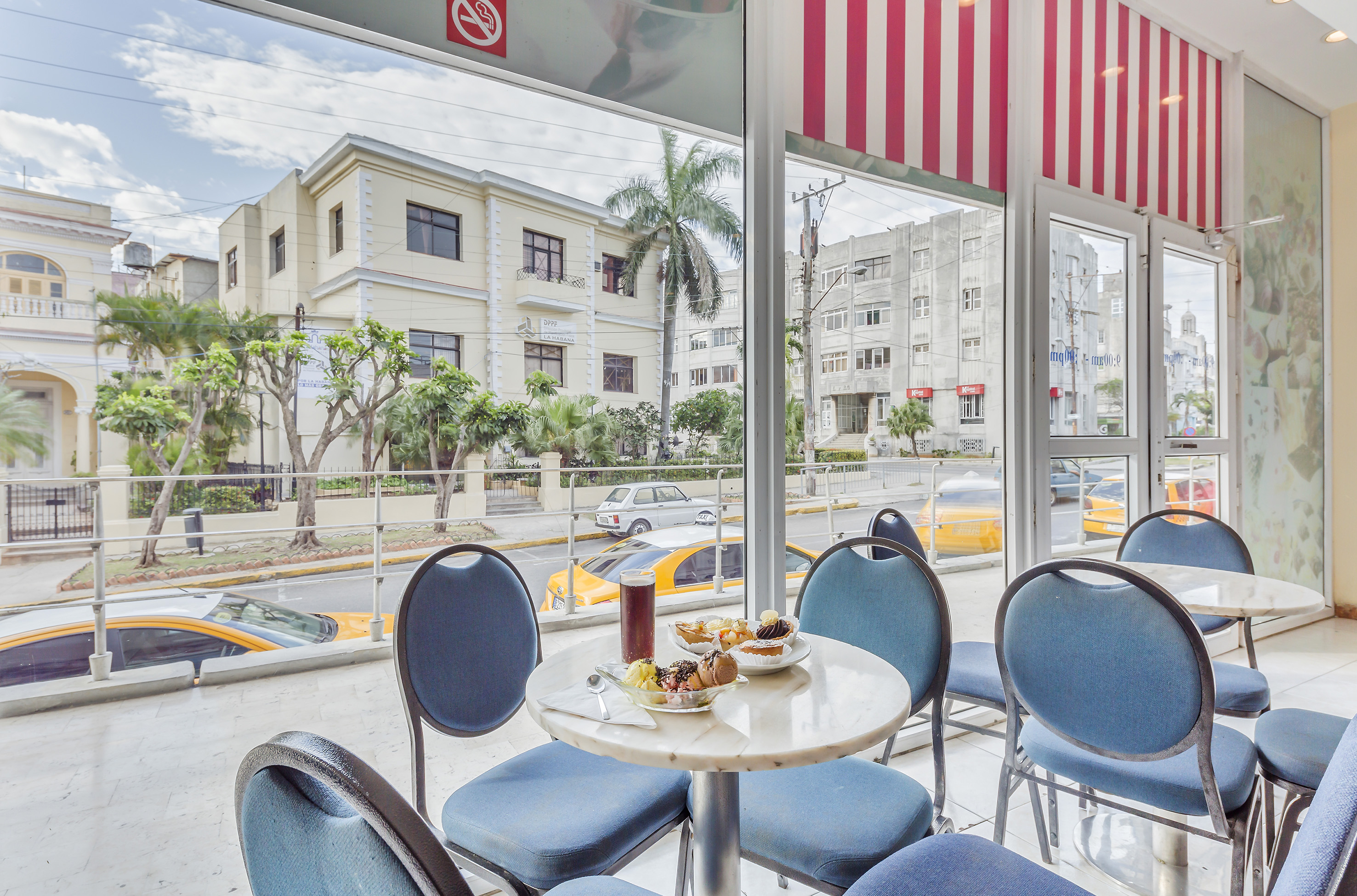 a table with food on it and blue chairs in front of a window