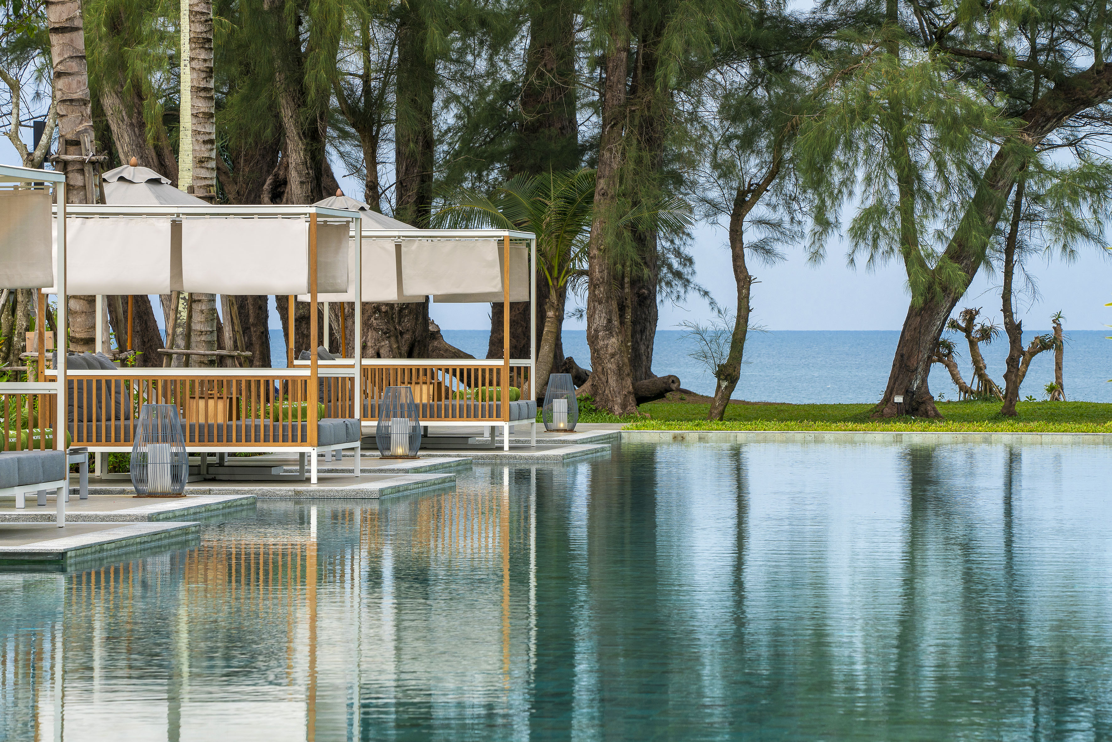 Luxury resort infinity pool with cabanas and ocean view.