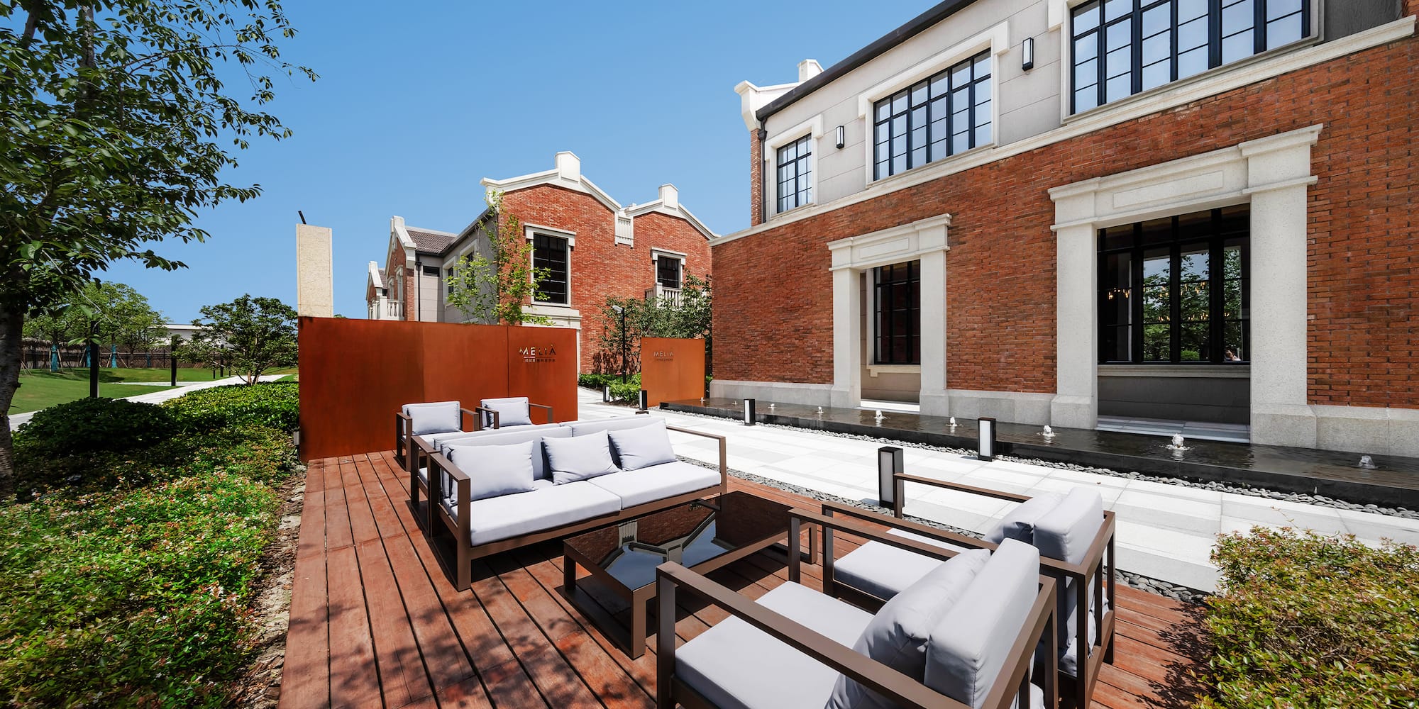 a patio with couches and a brick building