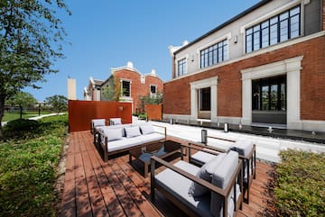a patio with couches and a brick building