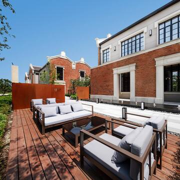 a patio with couches and a brick building