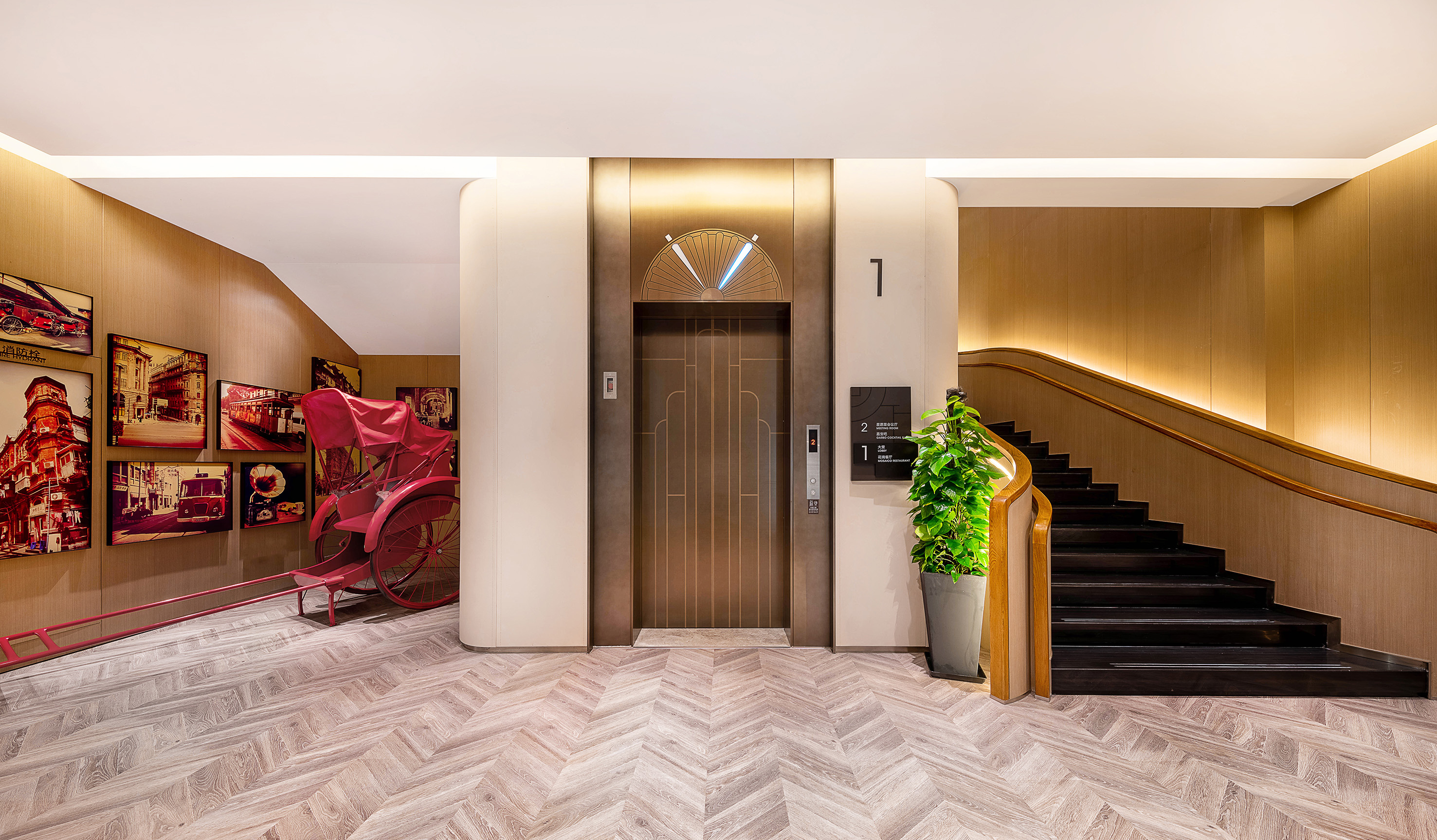 Hotel lobby: modern elevator, dark staircase, herringbone floor, red rickshaw.