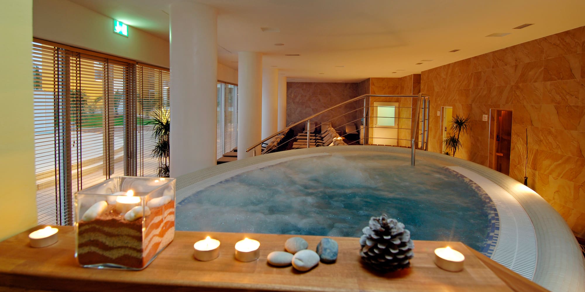 a hot tub with candles and pinecones