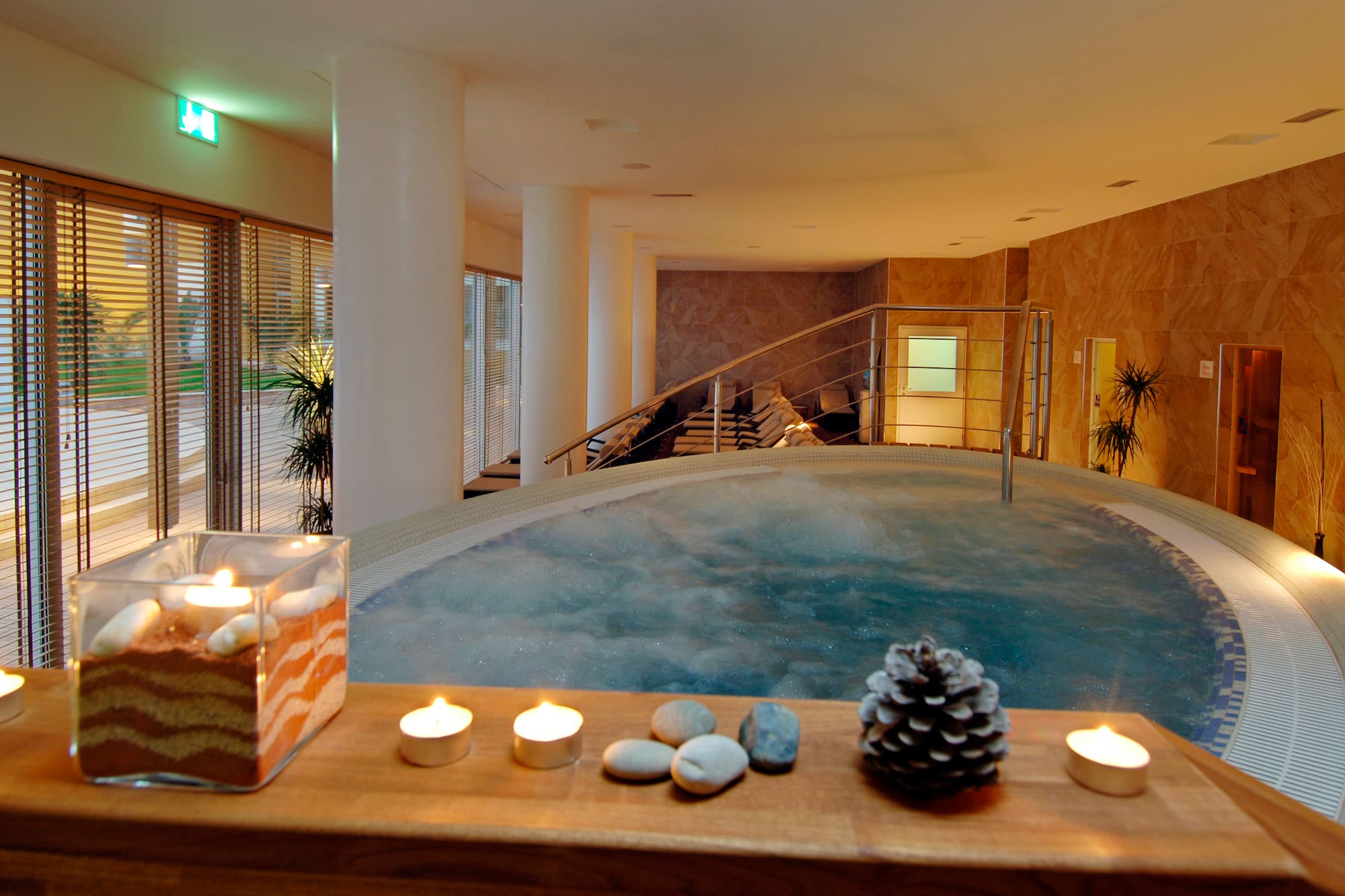 a hot tub with candles and pinecones