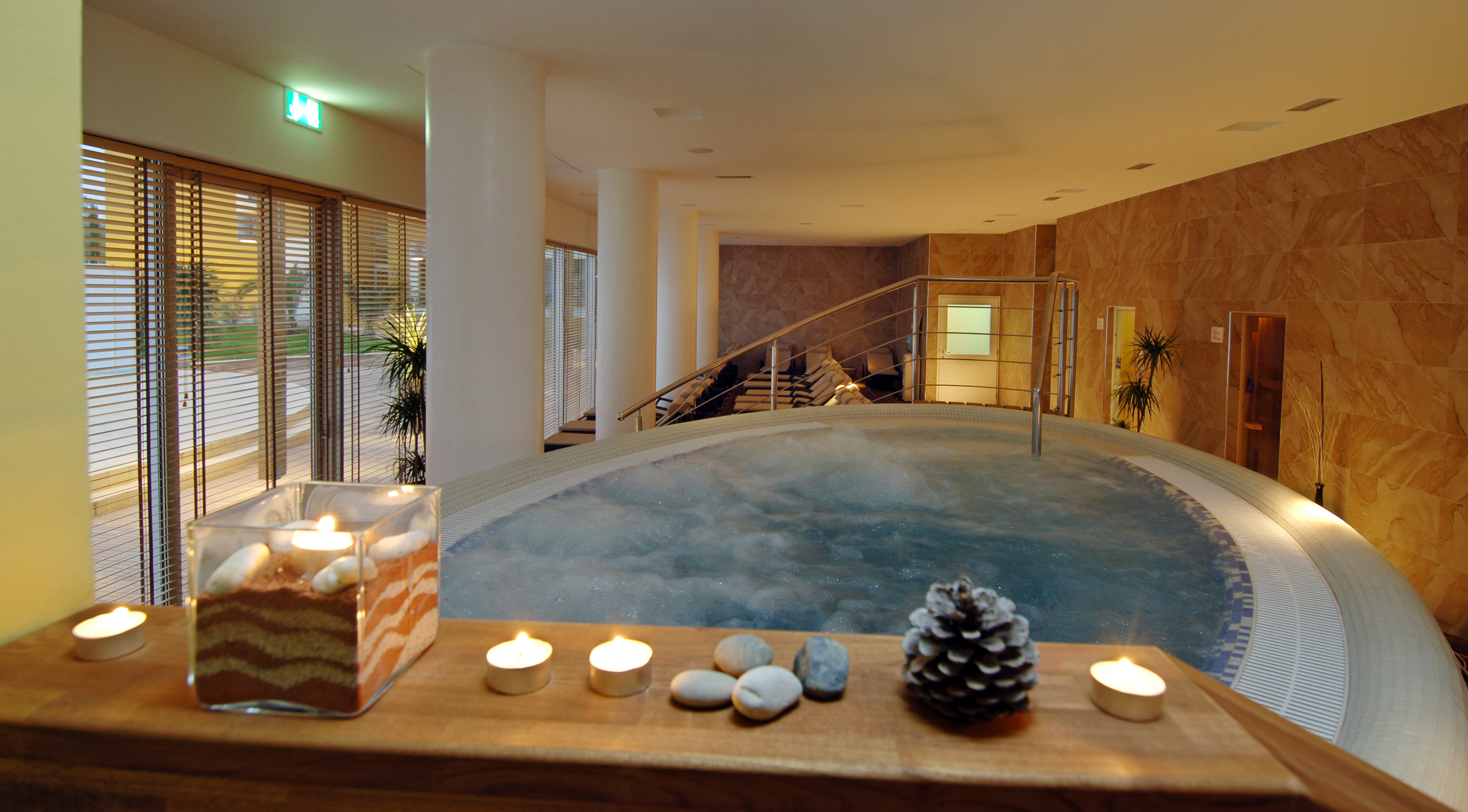 a hot tub with candles and pinecones