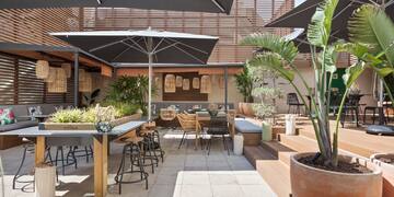 a patio with tables and chairs and umbrellas