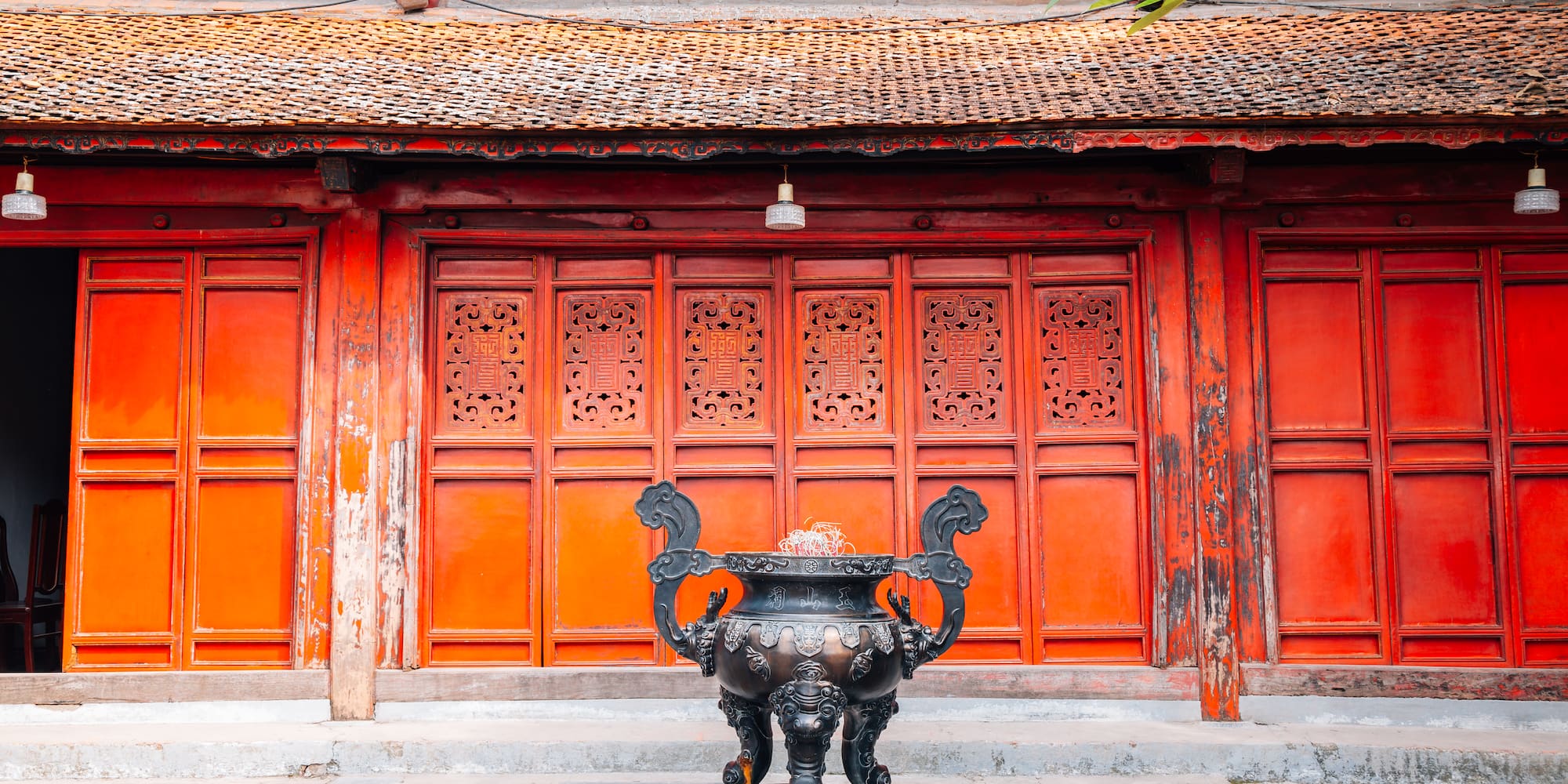 a large black urn in front of a red building