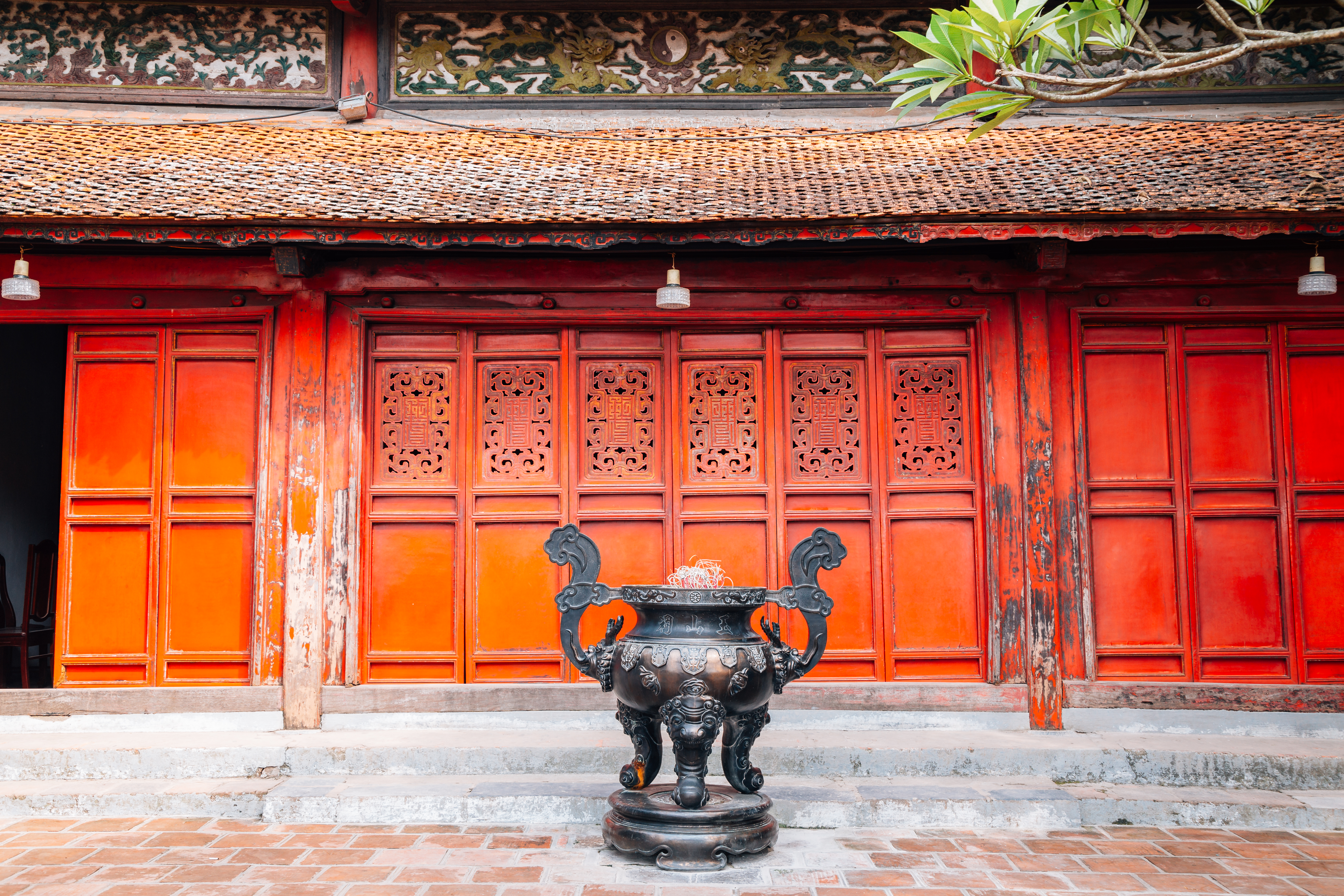 a large black urn in front of a red building