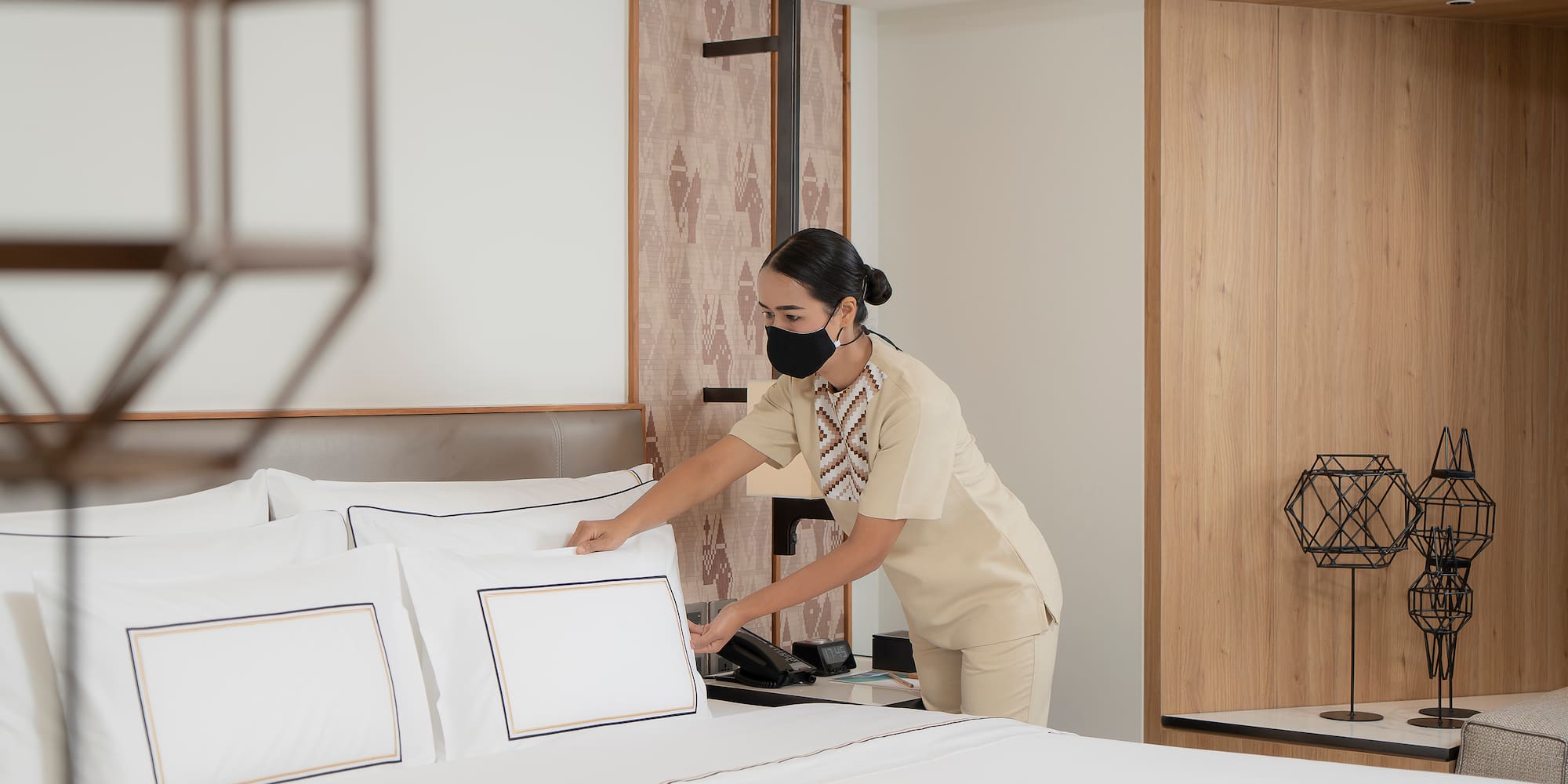 a woman wearing a mask and putting a bed on