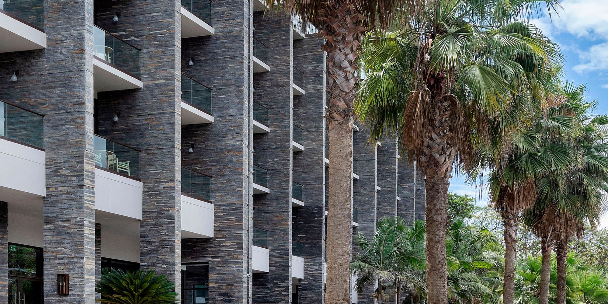 a building with palm trees and a walkway