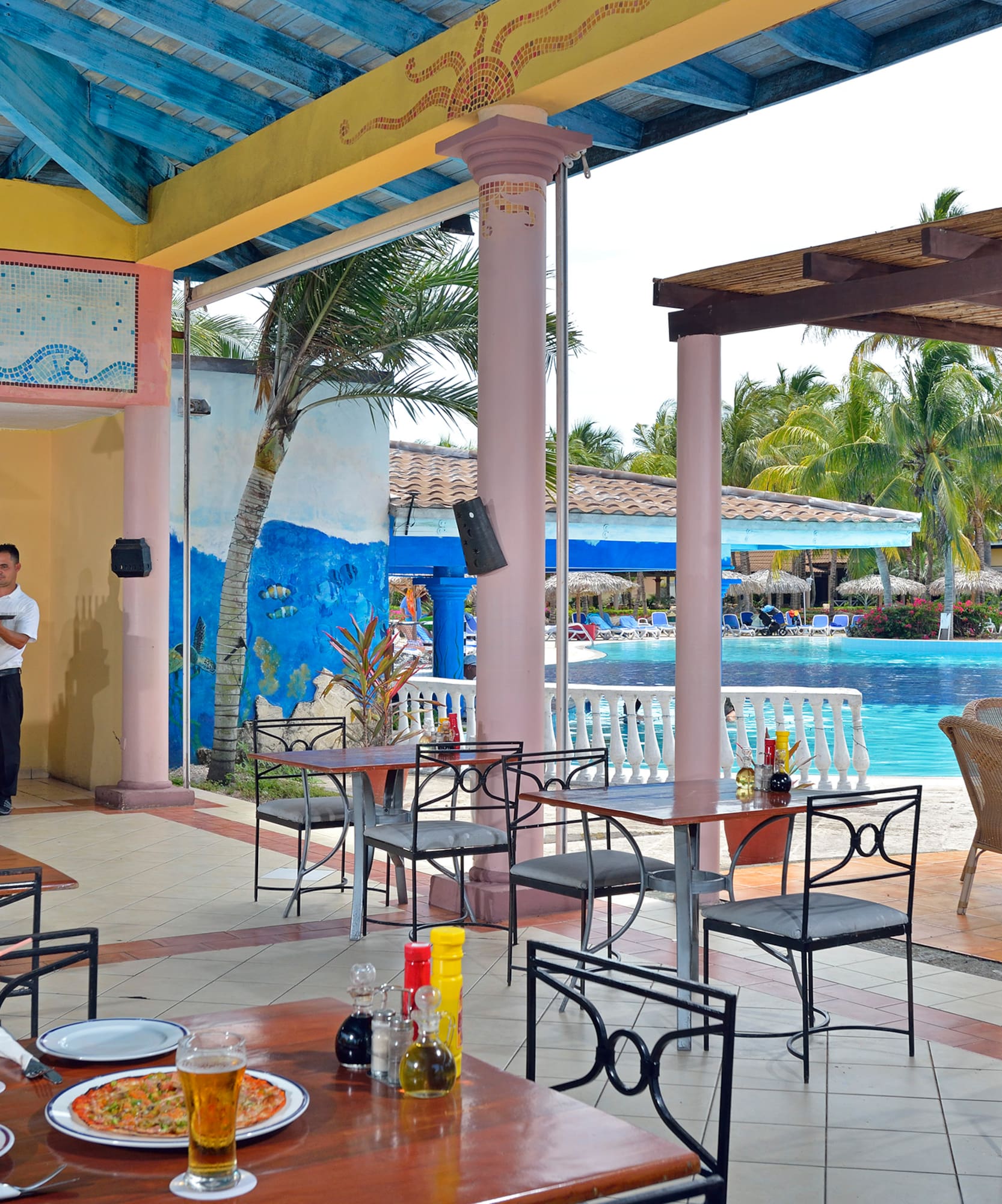 a man standing behind a table with food and drinks