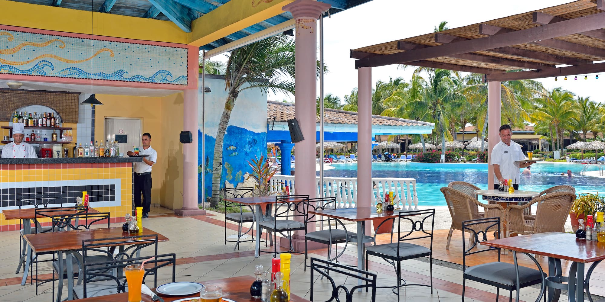 a man standing behind a table with food and drinks