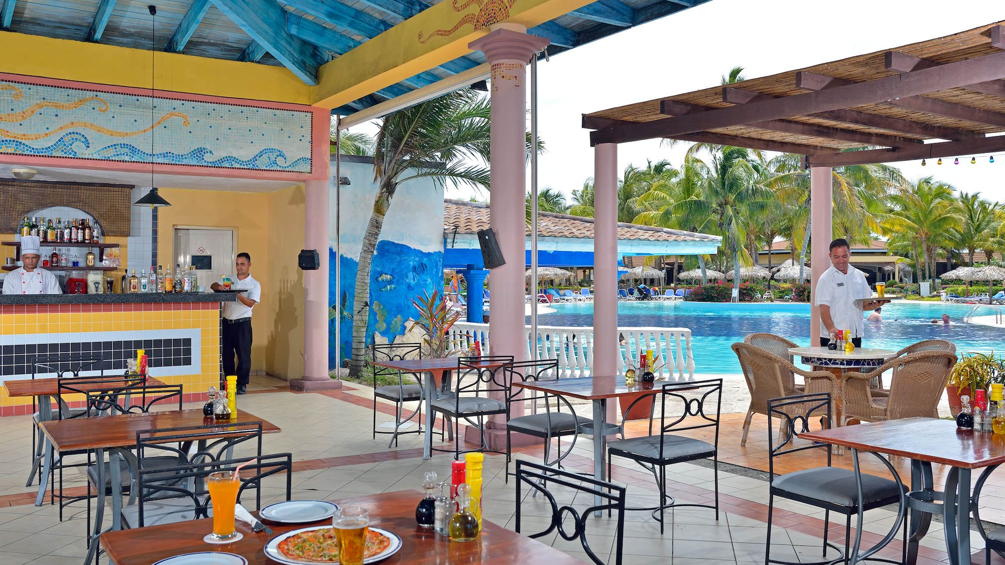 a man standing behind a table with food and drinks