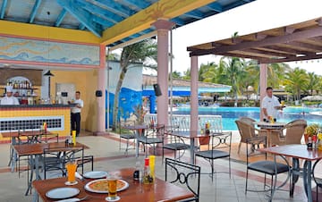 a man standing behind a table with food and drinks