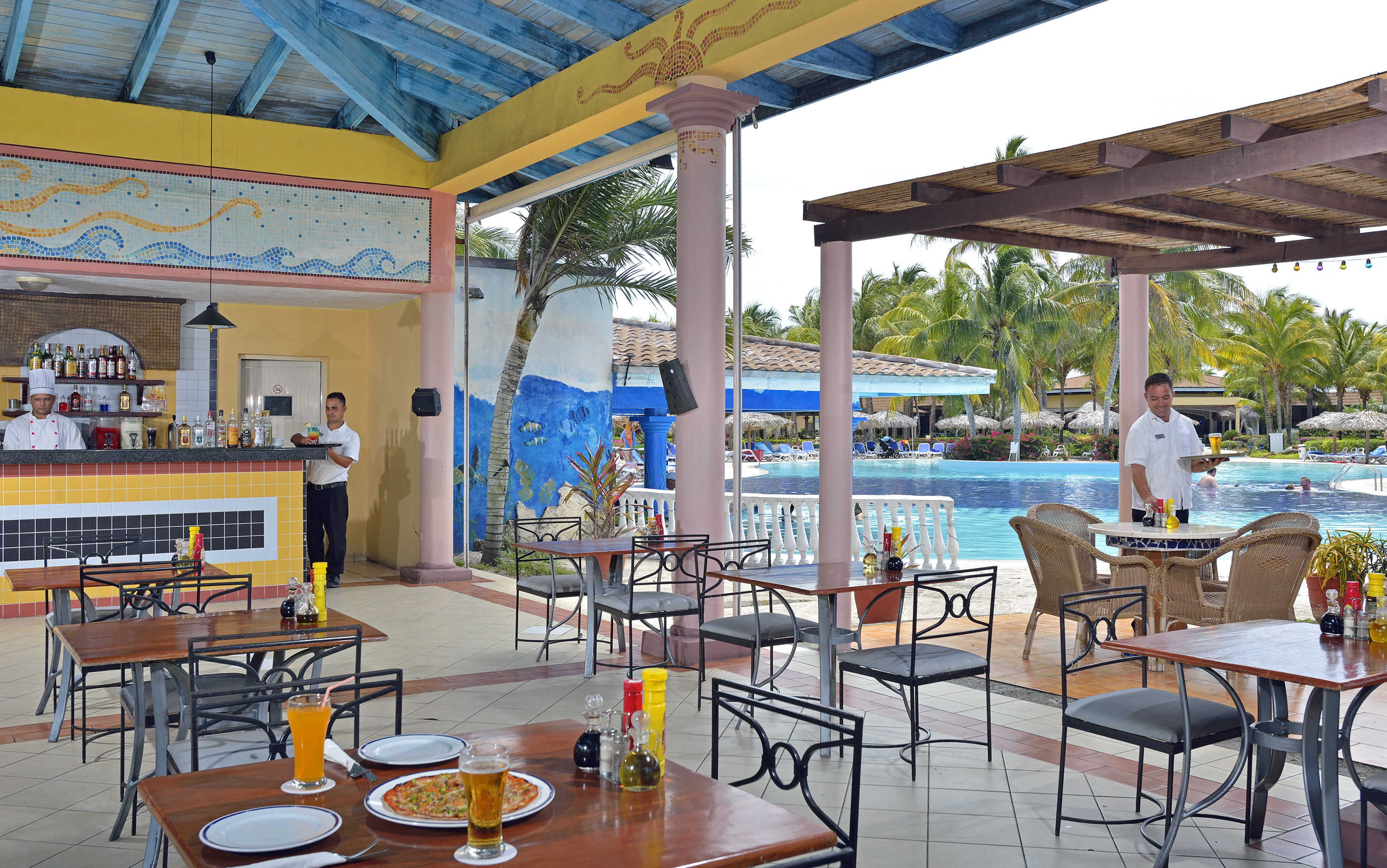 a man standing behind a table with food and drinks